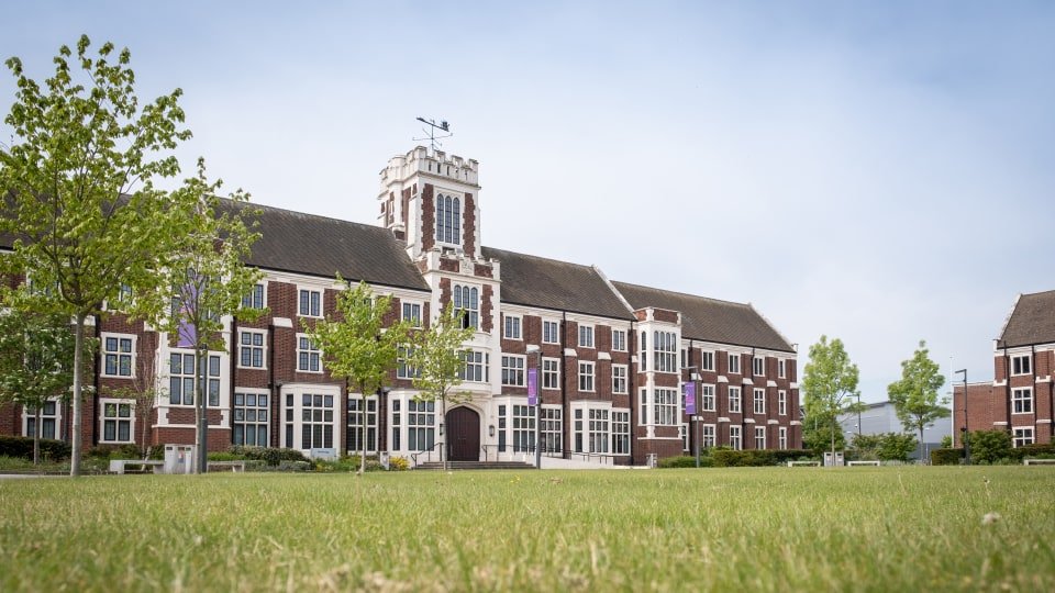 Image showing the outside of Loughborough university on a sunny day with freshly cut grass.